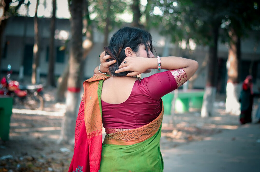 Portrait of a young South Asian British woman with a ponytail in a light shirt