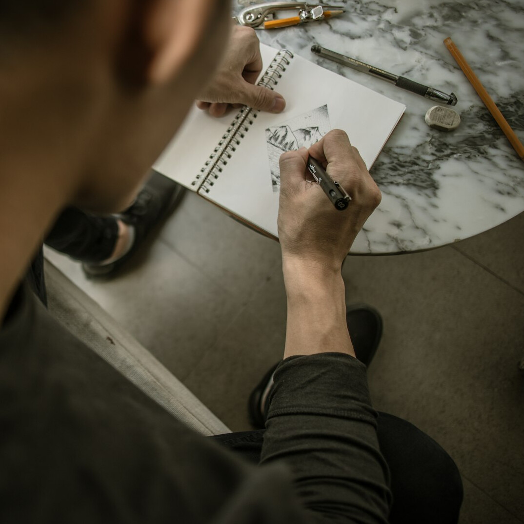 Production team planning a studio layout around a table with floor plans